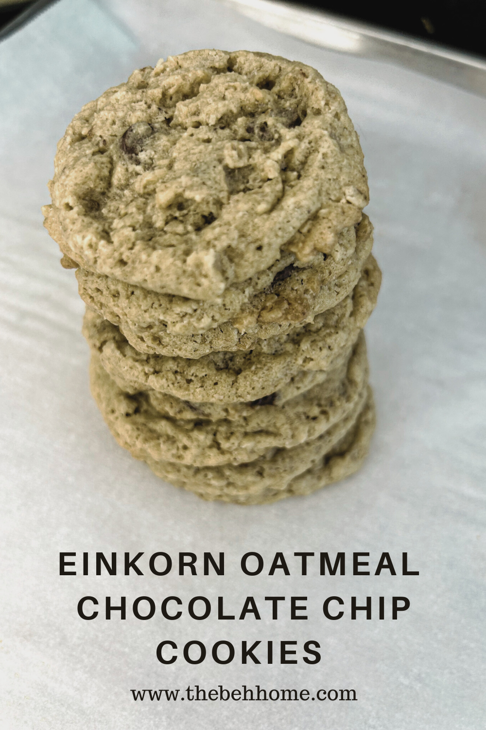 Stack of 8 oatmeal chocolate chip cookies on white parchment paper